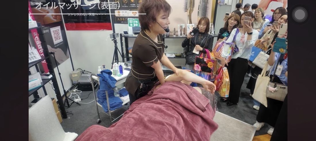 Beautyworld JapanでAmyがモデルの脚に実際の施術・技術を行う様子