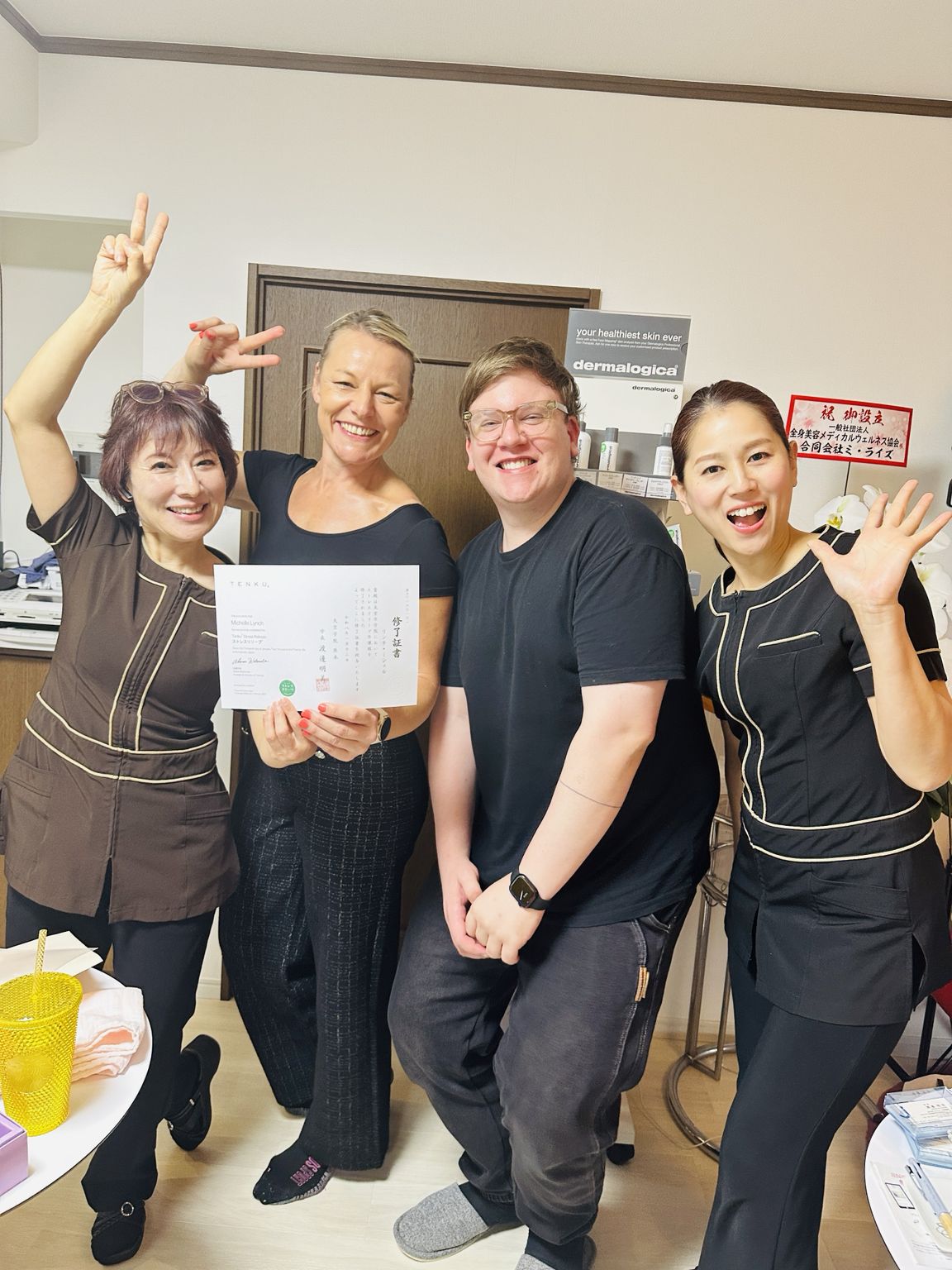 修了証を手にした受講生を囲むAmyら4名の記念写真